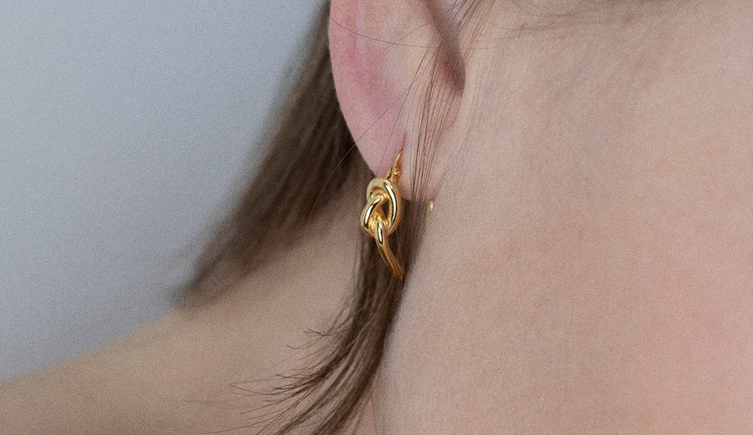 Minimal hoop earrings Europe displayed on a model's ear, showcasing modern elegance in gold.