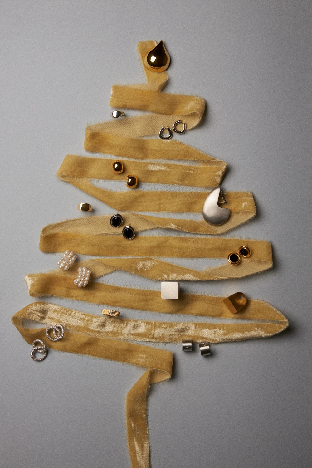 After Christmas jewelry style tips featuring elegant pieces arranged like a Christmas tree.