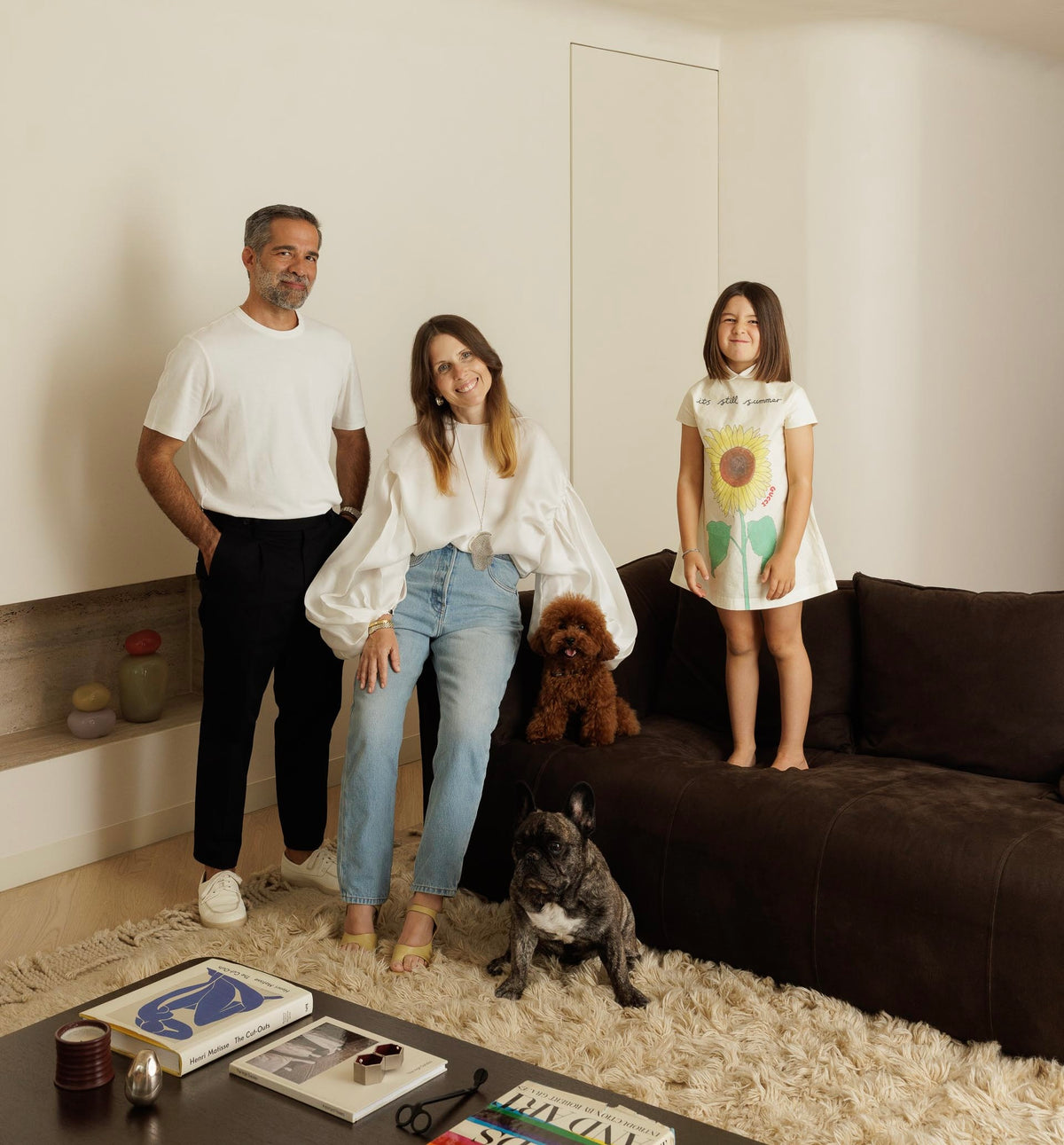 Familie mit drei Personen und zwei Hunden in einem Wohnzimmer
