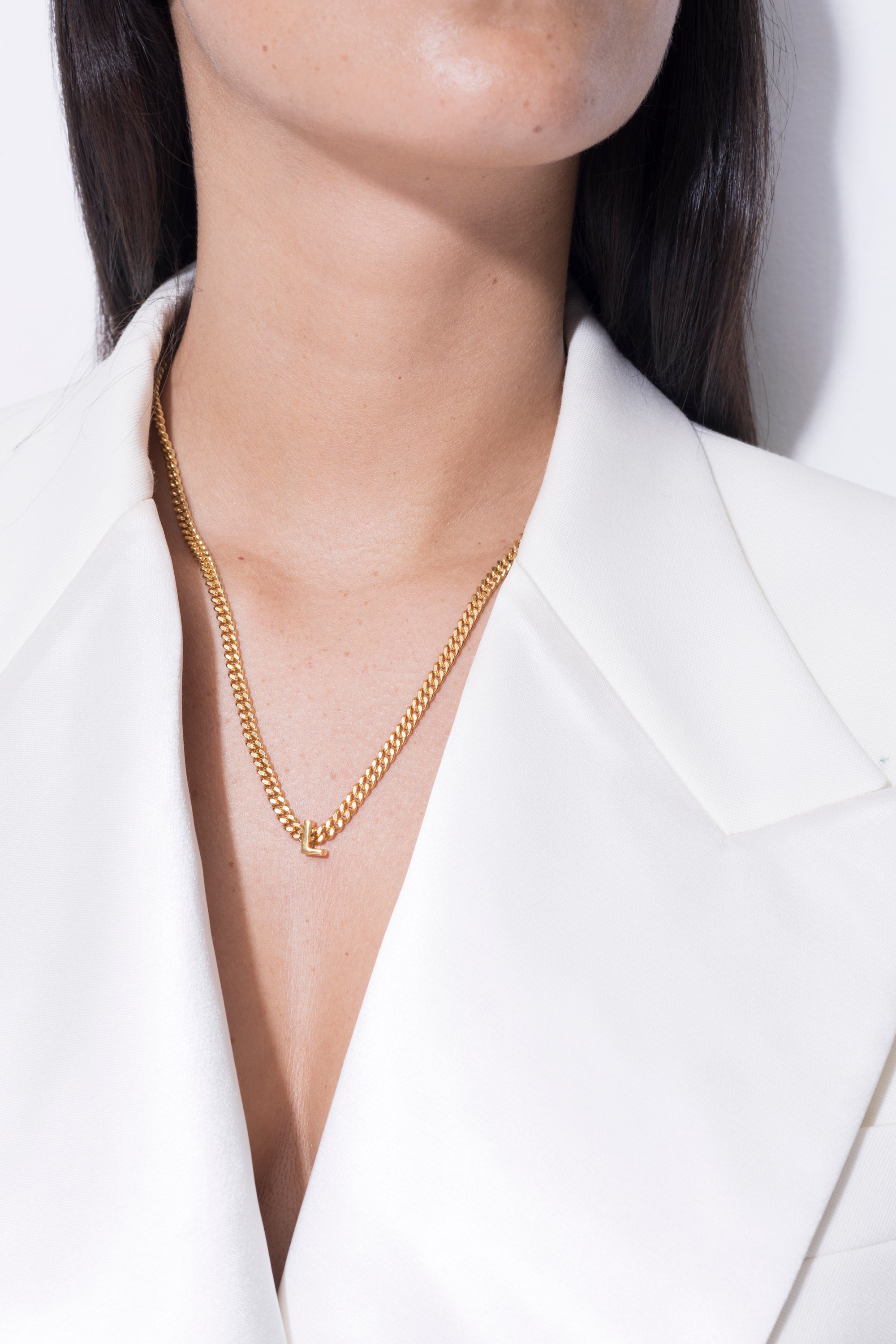 model wearing alphabet necklace with pendant L in gold