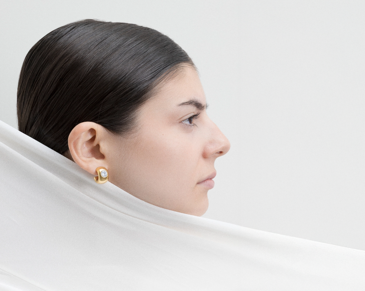 Profile view of a woman wearing elegant earrings and a sleek scarf, showcasing 925 sterling silver jewellery choices.