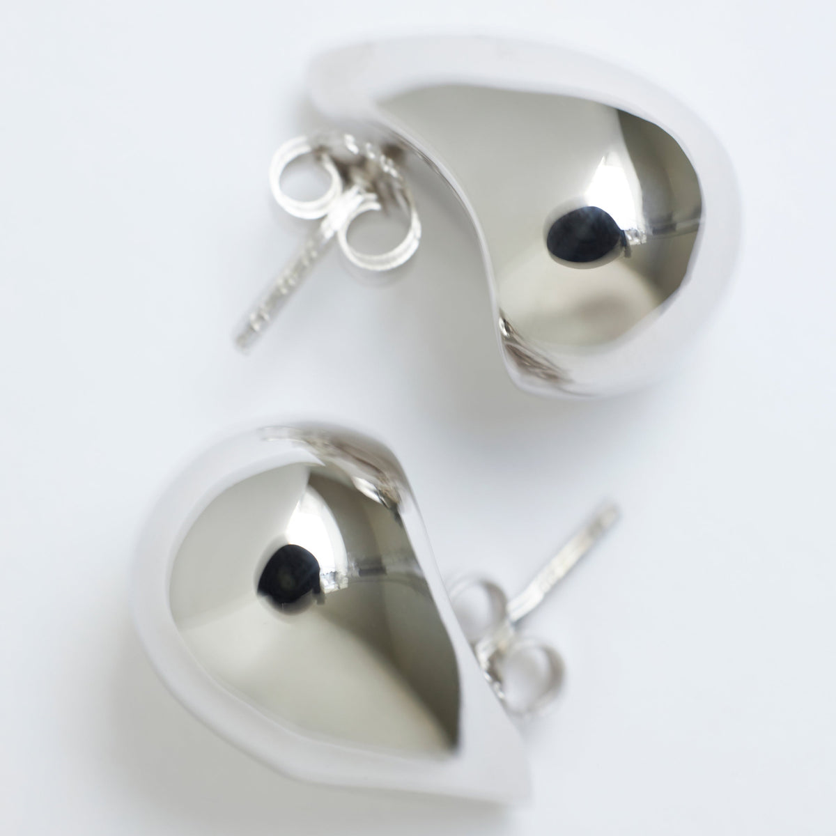 Silver heart-shaped earrings on a white background