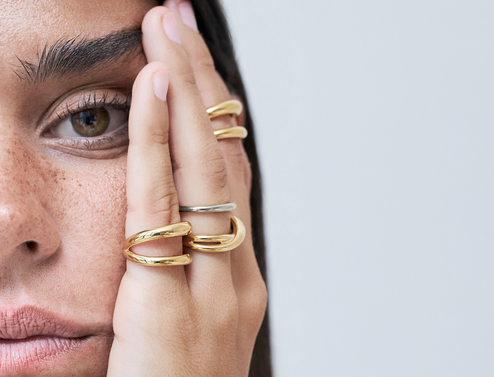 Close-up of a women with gold rings and two-tone jewelry