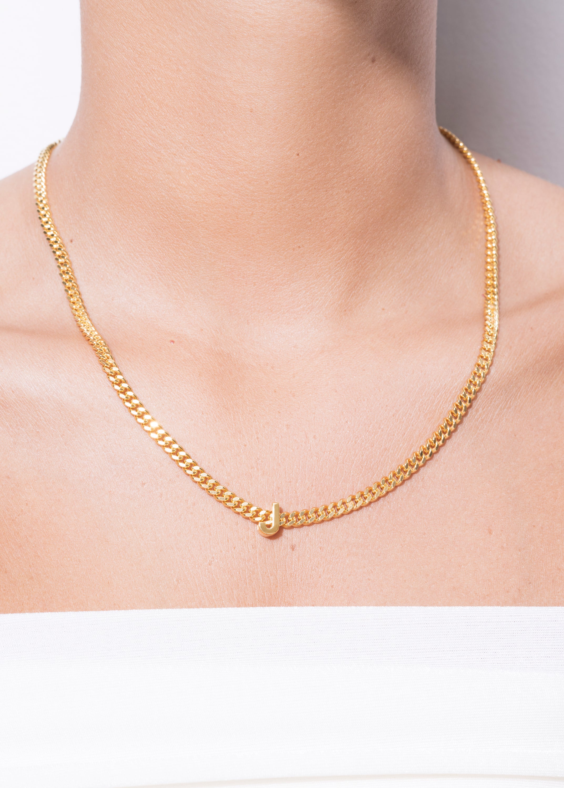 model wearing alphabet necklace with pendant J in gold