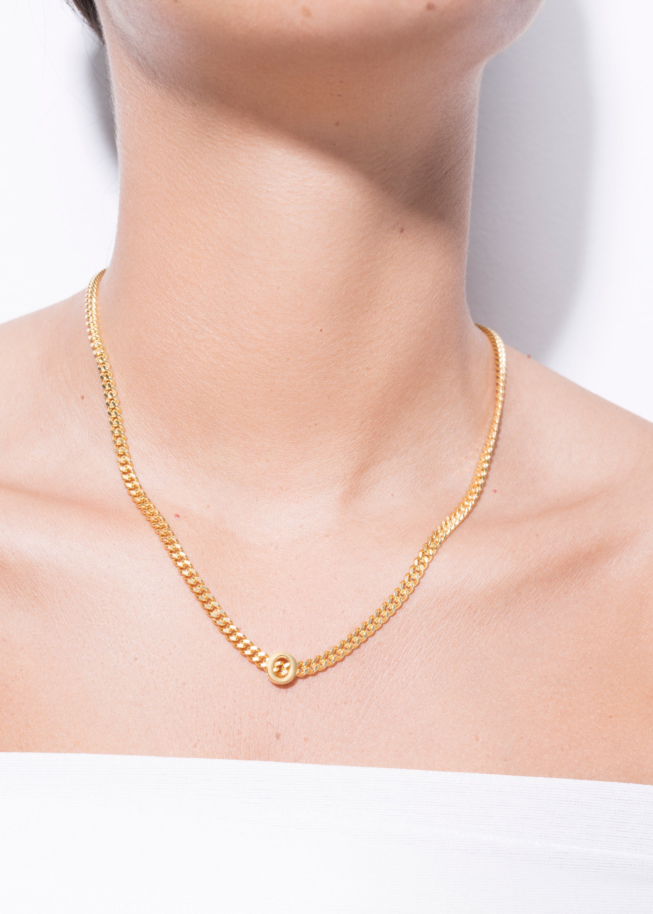 model wearing alphabet necklace with pendant O in gold