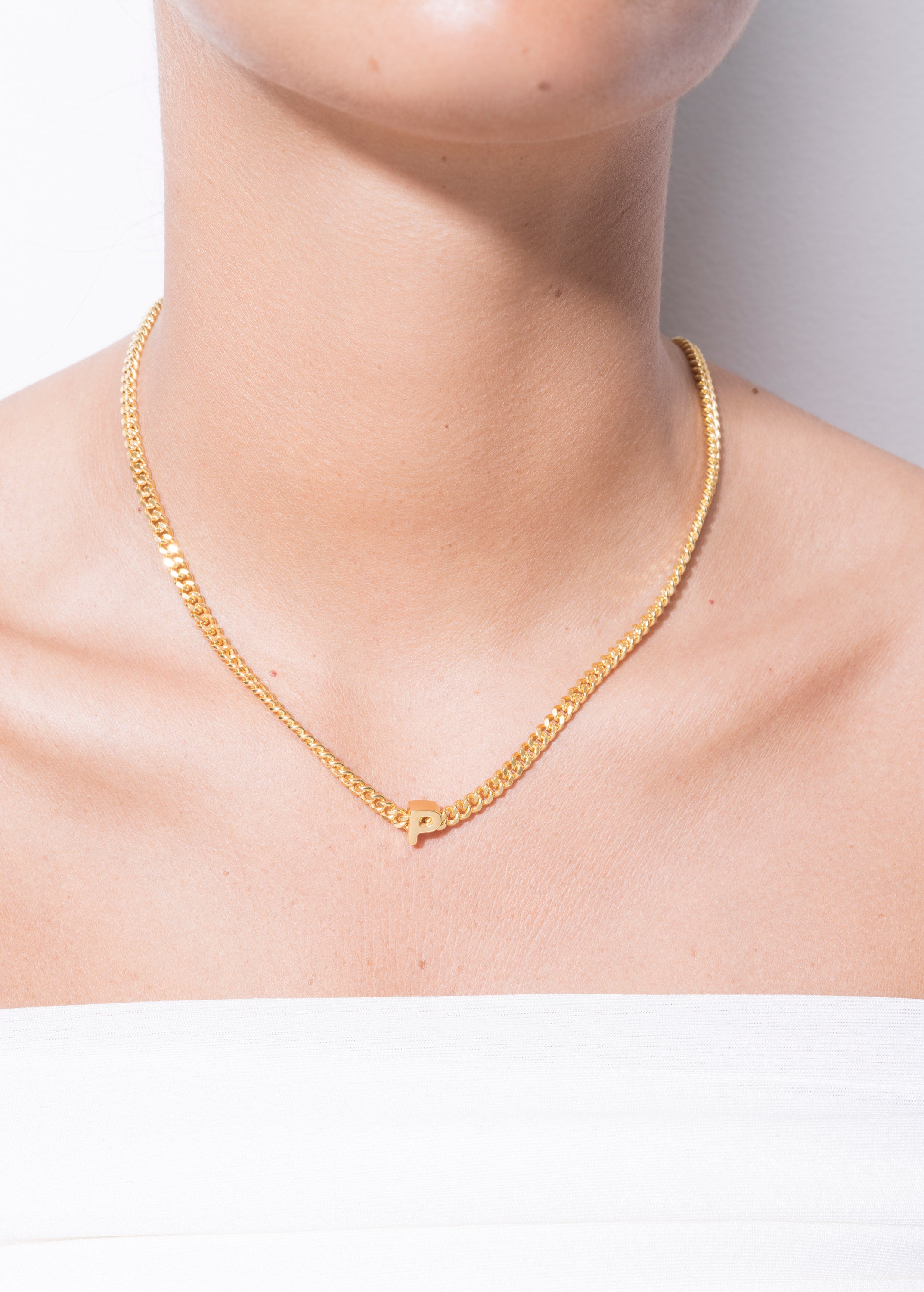 model wearing alphabet necklace with pendant P in gold