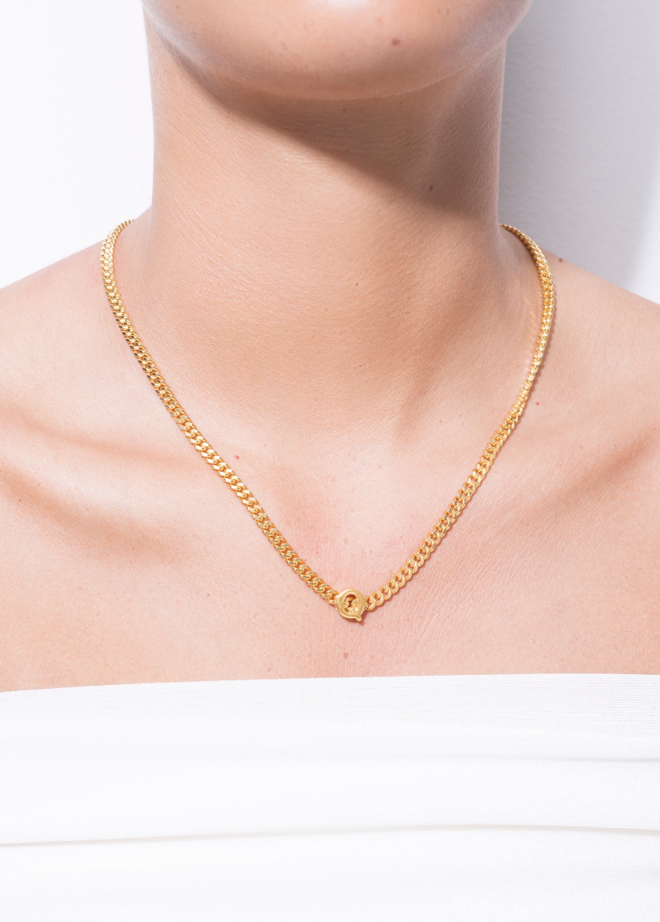 model wearing alphabet necklace with pendant Q in gold