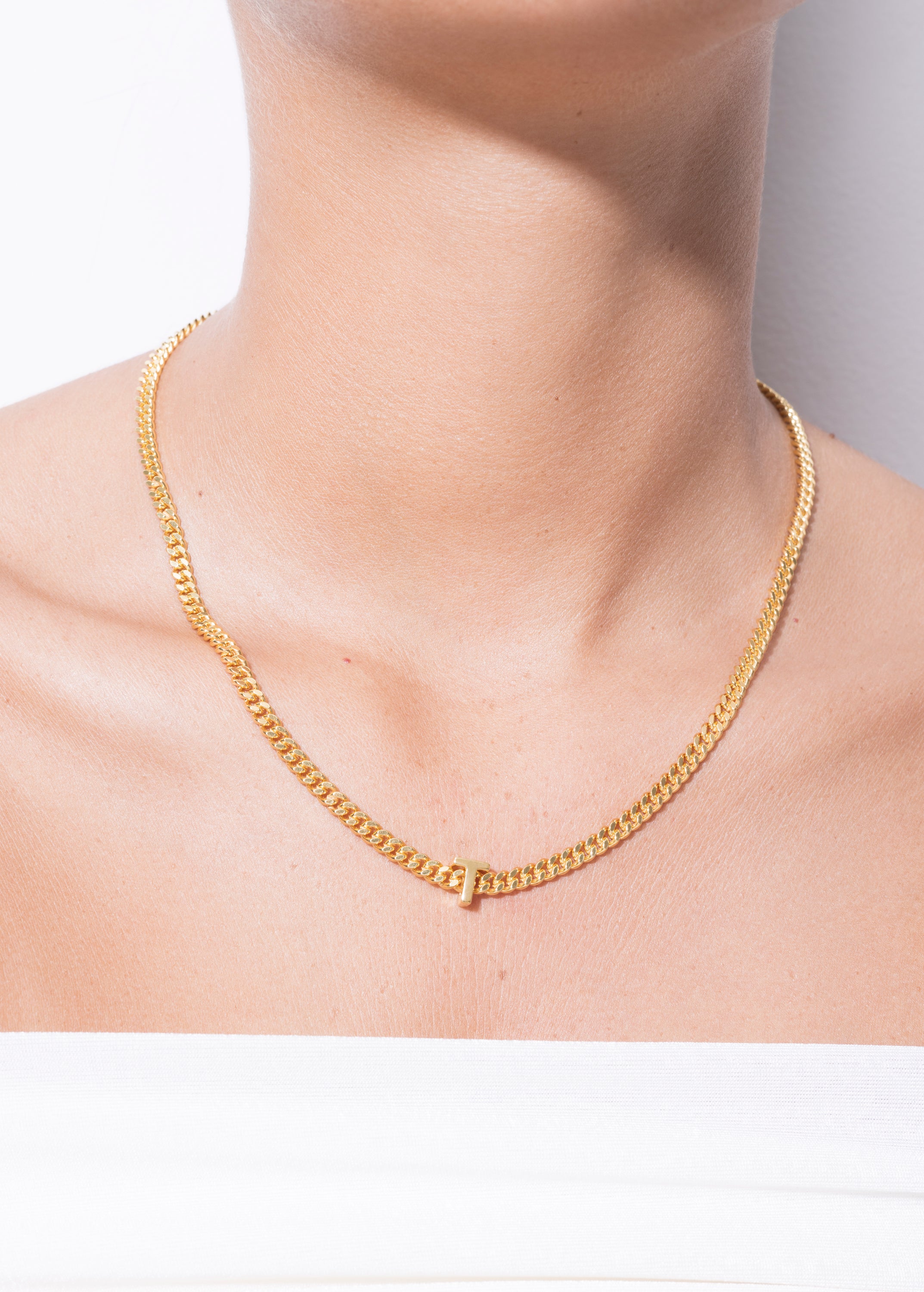 model wearing alphabet necklace with pendant T in gold