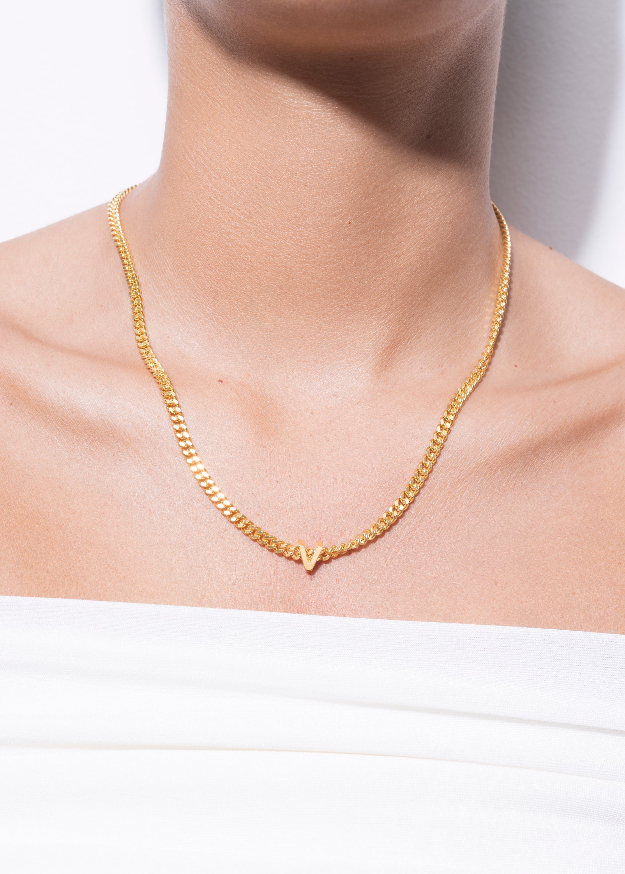 model wearing alphabet necklace with pendant V in gold