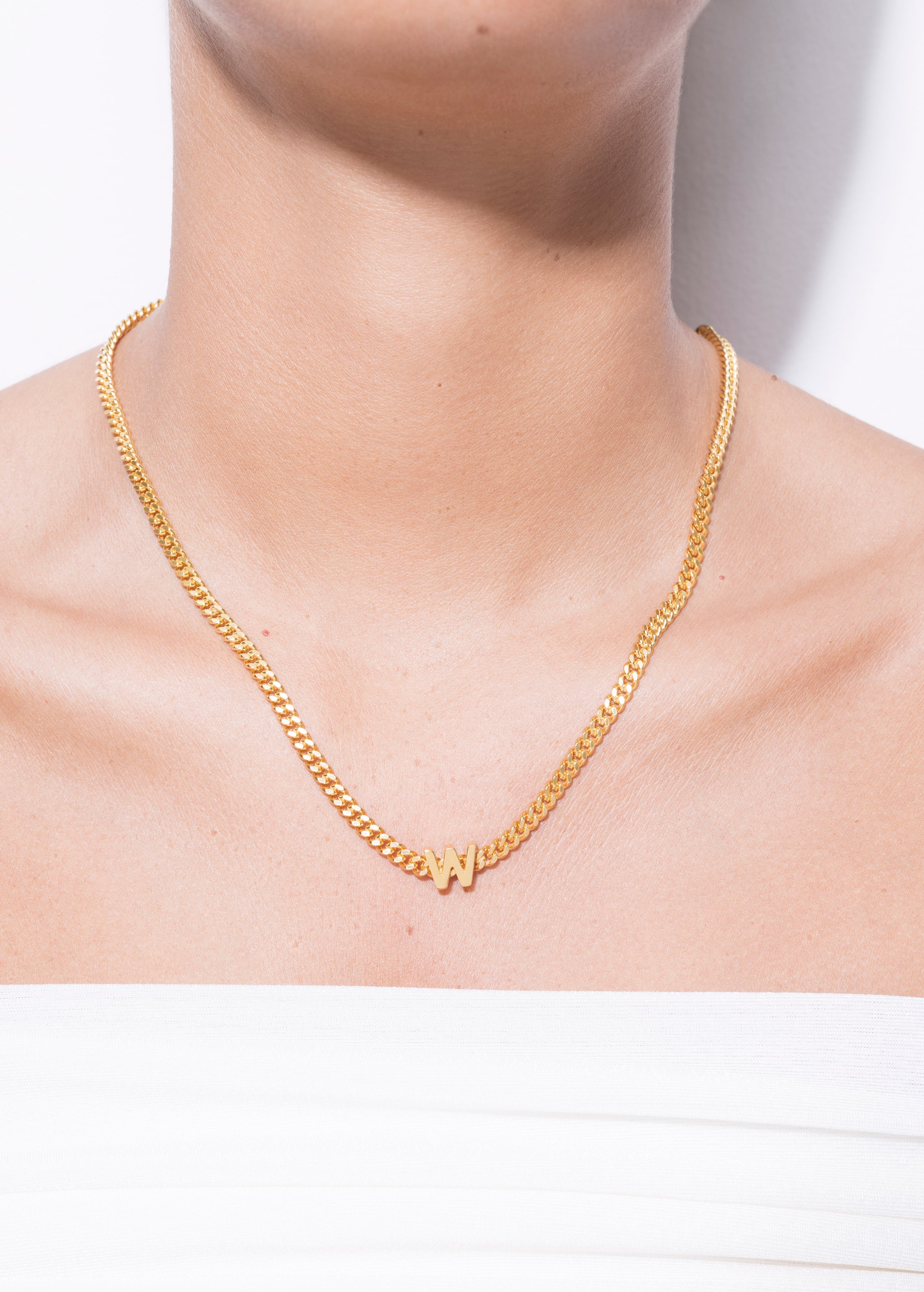 model wearing alphabet necklace with pendant W in gold