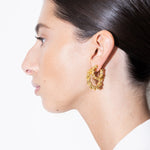 model wearing mini bia earrings and bia earrings in gold