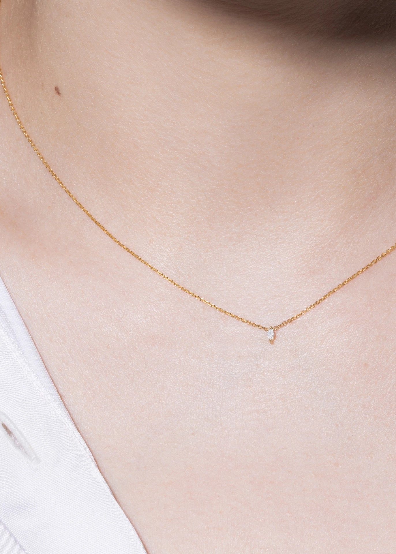 Gold necklace on a person's neck with a soft background