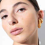 model wearing fiona earrings and fiona huggies in gold