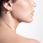 model wearing laura earrings in gold