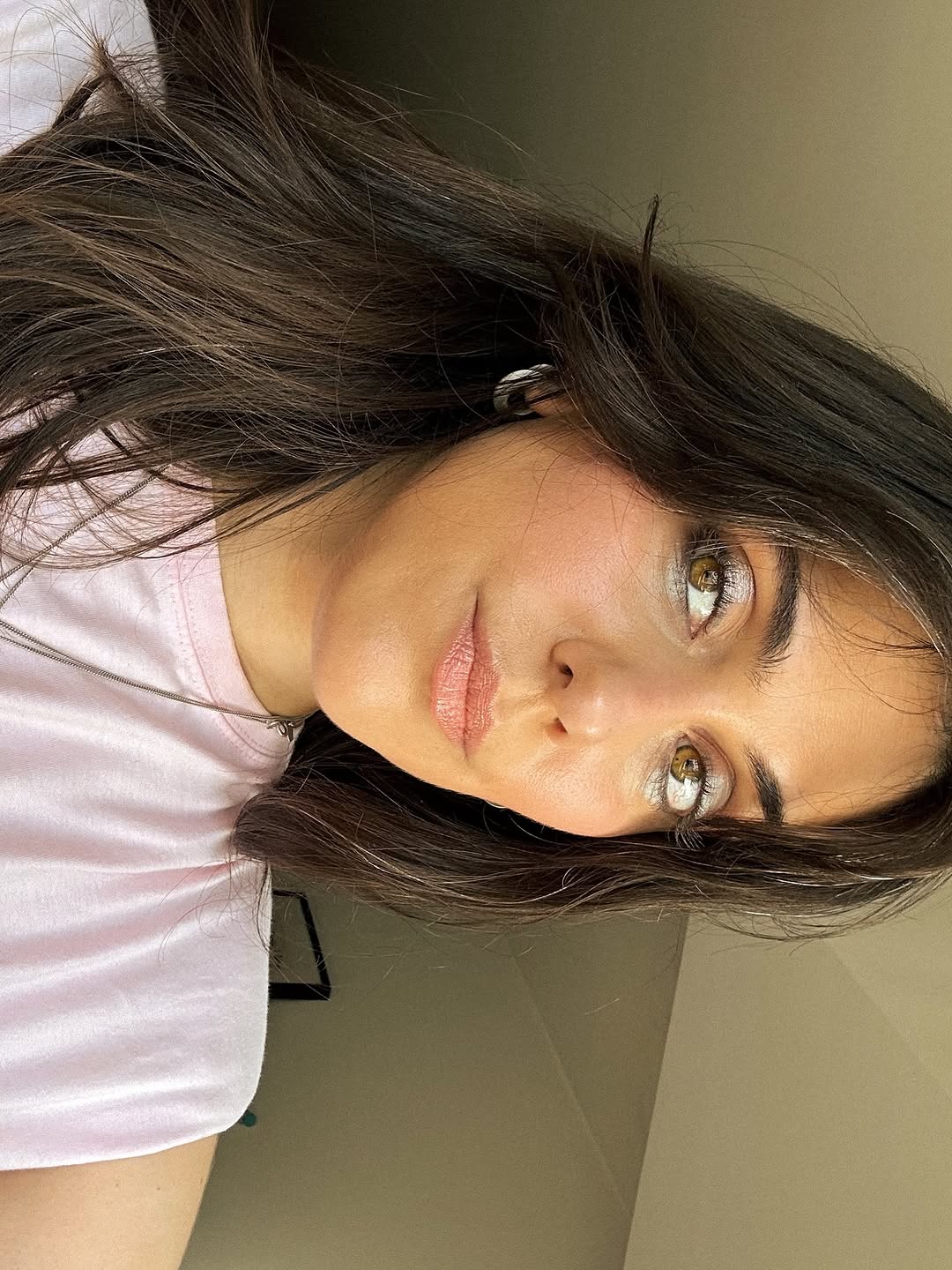 Close-up of a person with shoulder-length hair against a neutral background