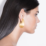 model wearing pam earrings in gold